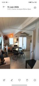 a kitchen and a living room with a table and chairs at La cabane provençale in Chamaret