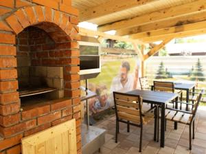 a brick patio with a table and a brick oven at Ograda Bunicului Seaca in Gura Văii