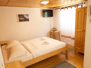 a bedroom with a bed with white sheets and a window at Ograda Bunicului Seaca in Gura Văii +55 photos
