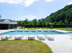 a swimming pool with lounge chairs and a bunch ofitures at Ograda Bunicului Seaca in Gura Văii