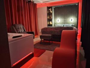 a bedroom with a bed and a bathroom with red lights at Arlove Room in Arlon