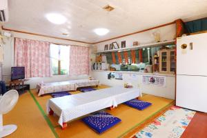 a living room with two beds and a kitchen at 民宿池田屋 in Taketomi