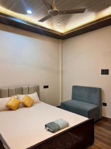 a bedroom with a bed and a blue chair at Rodali stay in Dibrugarh