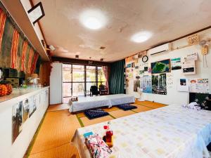 a room with two beds and a table in it at 民宿池田屋 in Taketomi