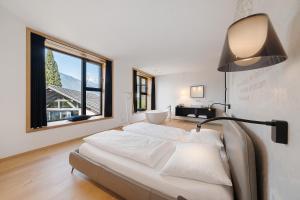 a bedroom with a bed with a lamp and a window at Wine Lodge Pratenberg in Merano