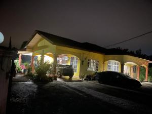 a yellow house with a car parked in front of it at Villa Cempaka II in Changlun