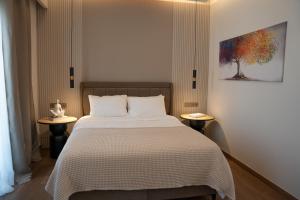 a bedroom with a large bed with two tables at LUMINA Luxury Suites in Missolonghi