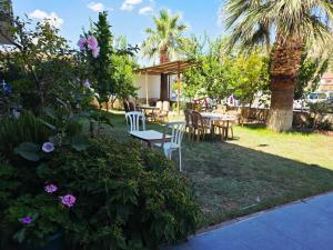 a yard with tables and chairs and palm trees at Haciely Thermal Otel in Denizli
