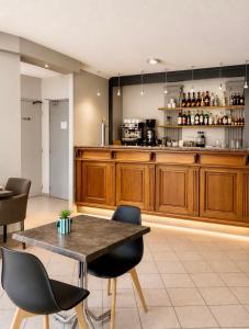 a kitchen with a table and chairs in a room at Apparthotel de Langogne in Langogne