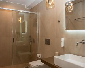 a bathroom with a shower and a sink and a toilet at LUMINA Luxury Suites in Missolonghi +40 photos