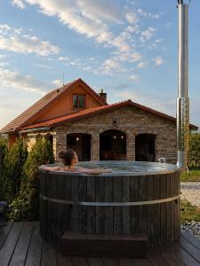 a woman sitting in a hot tub in front of a house at Kokodáák in Troskotovice