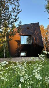 a house in the middle of a field with flowers at Meteorite House in Kontiolahti