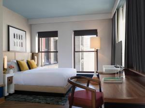 a bedroom with a bed and a desk and windows at Kimpton Schofield Hotel by IHG in Cleveland +76 photos