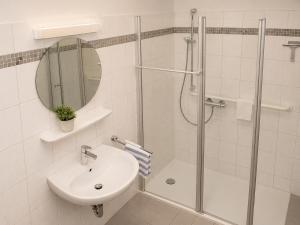 a white bathroom with a shower and a sink at Gästehaus Stillecke in Erwitte +7 photos
