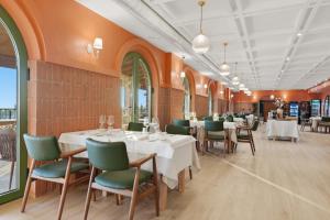 a dining room with white tables and green chairs at Agroturizem Cialda in Shkallnur