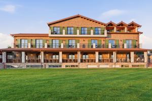 a large brick house with a large lawn at Agroturizem Cialda in Shkallnur