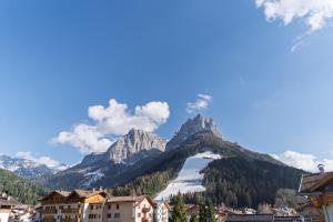 a town with mountains in the background with snow at Appartamenti Pollam by AMA Val di Fassa in Pozza di Fassa