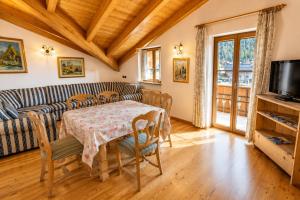 a living room with a table and a couch at Appartamenti Pollam by AMA Val di Fassa in Pozza di Fassa