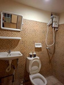 a bathroom with a shower and a toilet and a sink at U House Homeytel in Ban Tai