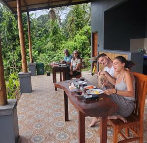 a group of people sitting at tables on a patio at The Grembeng in Undisan