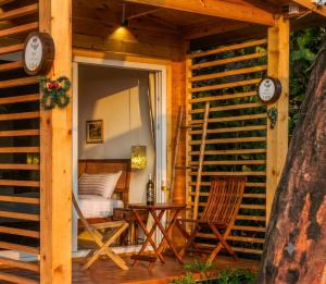 a porch of a cabin with a bed and chairs at Morii by the sea - Morjim Beach in Morjim