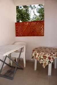 a table and a bench in front of a window at Pantera Rosa Village in Scalea