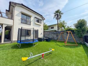 a yard with a swing set and a playground at Asobico焼津 in Yaizu