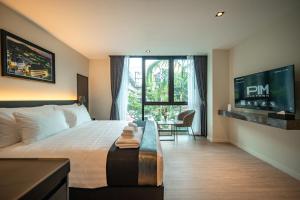 a hotel room with a bed and a large window at Pim Old Town in Chiang Mai