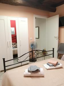 a bedroom with a bed with a fan and a mirror at La casetta di nonna Sesa in Viterbo