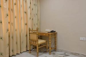 a desk with a chair next to a curtain at Iskcon guest house in Patna