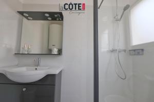 a white bathroom with a sink and a shower at Duplex Villebois in Port-de-Bouc