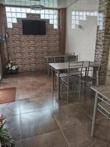 a dining room with tables and chairs and a tv on a brick wall at La Kosta Zatoka in Zatoka