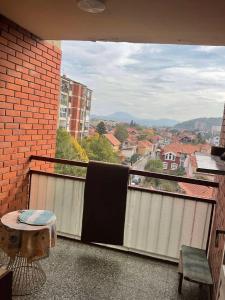 a balcony with a table and a view of a city at City centar apartman in Zaječar