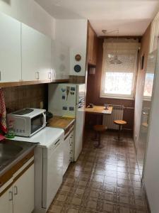 a kitchen with white cabinets and a microwave at City centar apartman in Zaječar