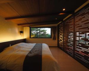 a bedroom with a large bed and a window at Amakusa Tenku No Fune in Kami Amakusa