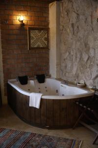 a bath tub in a room with a brick wall at Zeppelin Cappadocia in Uçhisar +93 photos