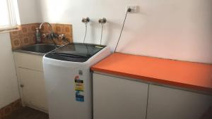 a small kitchen with a sink and a refrigerator at R1 Bright Spacious Room near Perth Airport in Perth