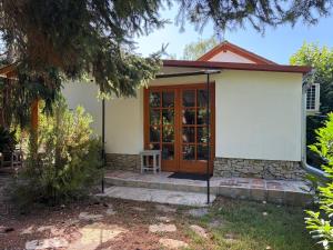 a small white house with a wooden door at Fonfa Liget in Sénye