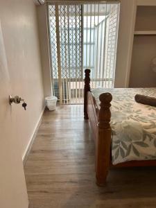 a bedroom with a bed and a large window at R1 Bright Spacious Room near Perth Airport in Perth