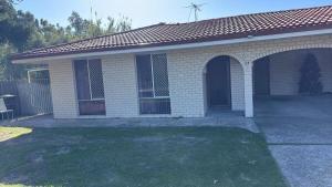 a brick house with a gate and a driveway at R1 Bright Spacious Room near Perth Airport in Perth