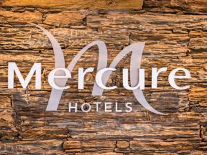 a sign for magic hotel on a stone wall at Mercure Hotel & Spa Bastia Biguglia in Biguglia