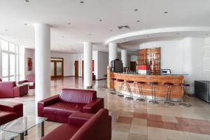 eine Lobby mit roten Sofas und einer Bar in der Unterkunft Hotel Fenix - All Inclusive in Sonnenstrand