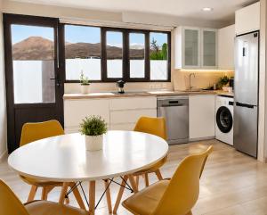 a kitchen with a white table and chairs at Volcán de sal in Teguise