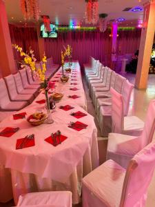 a banquet hall with white tables and white chairs at London Restaurant Hotel in Kukës