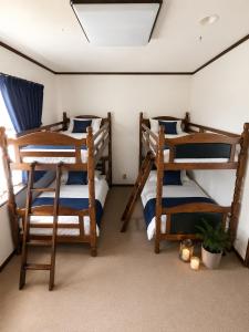 a room with three bunk beds and a skylight at Heart Warmer in Myoko