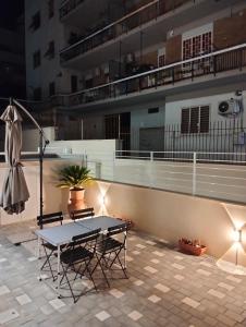 a patio with a table and chairs and an umbrella at La Casa di Mami in Velletri