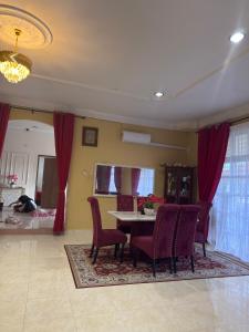 a dining room with a table and red chairs at Villa Cempaka II in Changlun