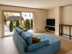 a living room with a blue couch and a television at Z-Apartment Parkgasse in Schladming