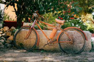 an orange bike parked next to a stone wall at Agriturismo Duca di Castelmonte in Trapani