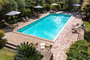 an overhead view of a swimming pool with chairs and umbrellas at Agriturismo Duca di Castelmonte in Trapani